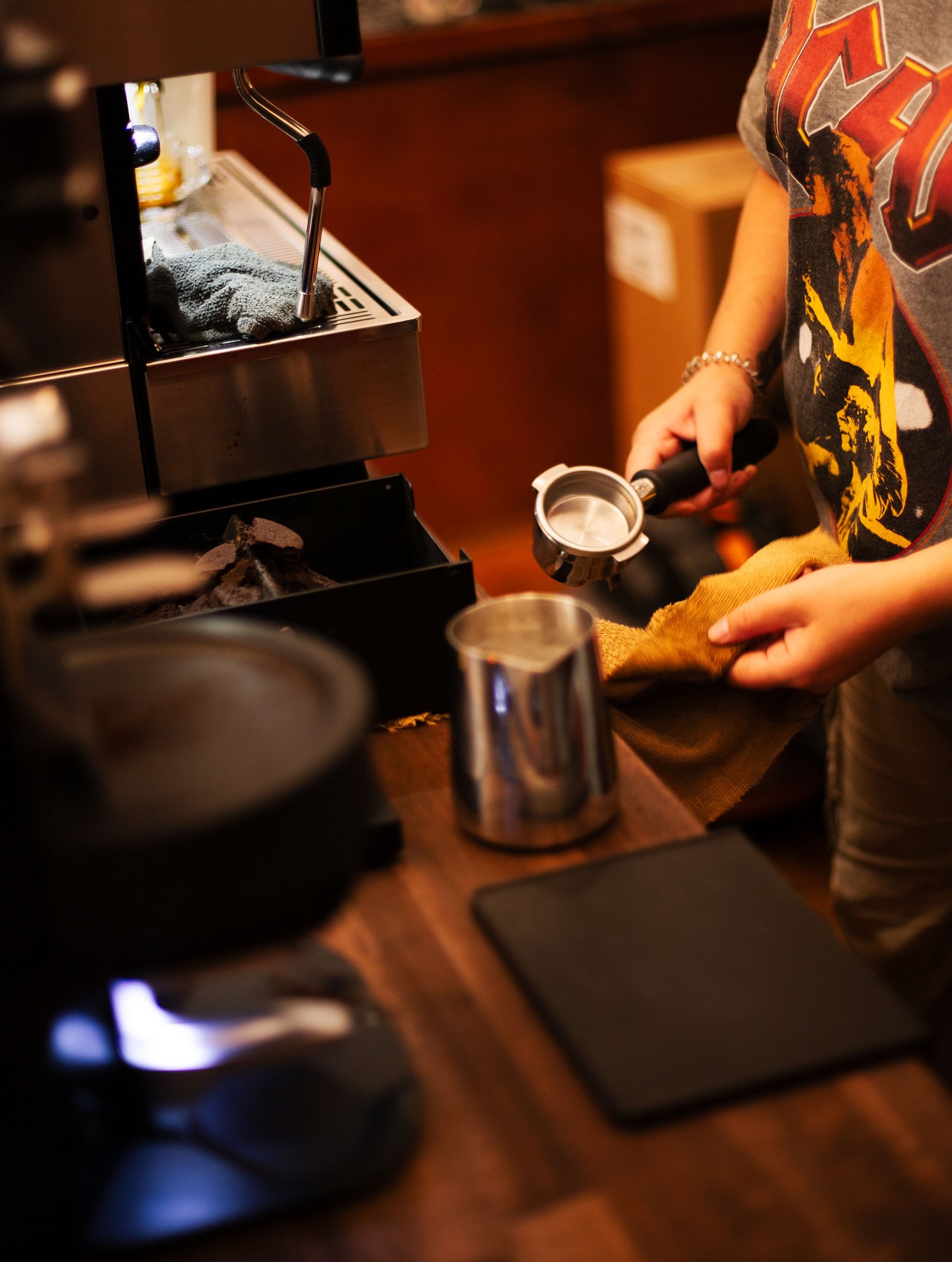 A barista preparing a portafilter beside the Our Place espresso machine