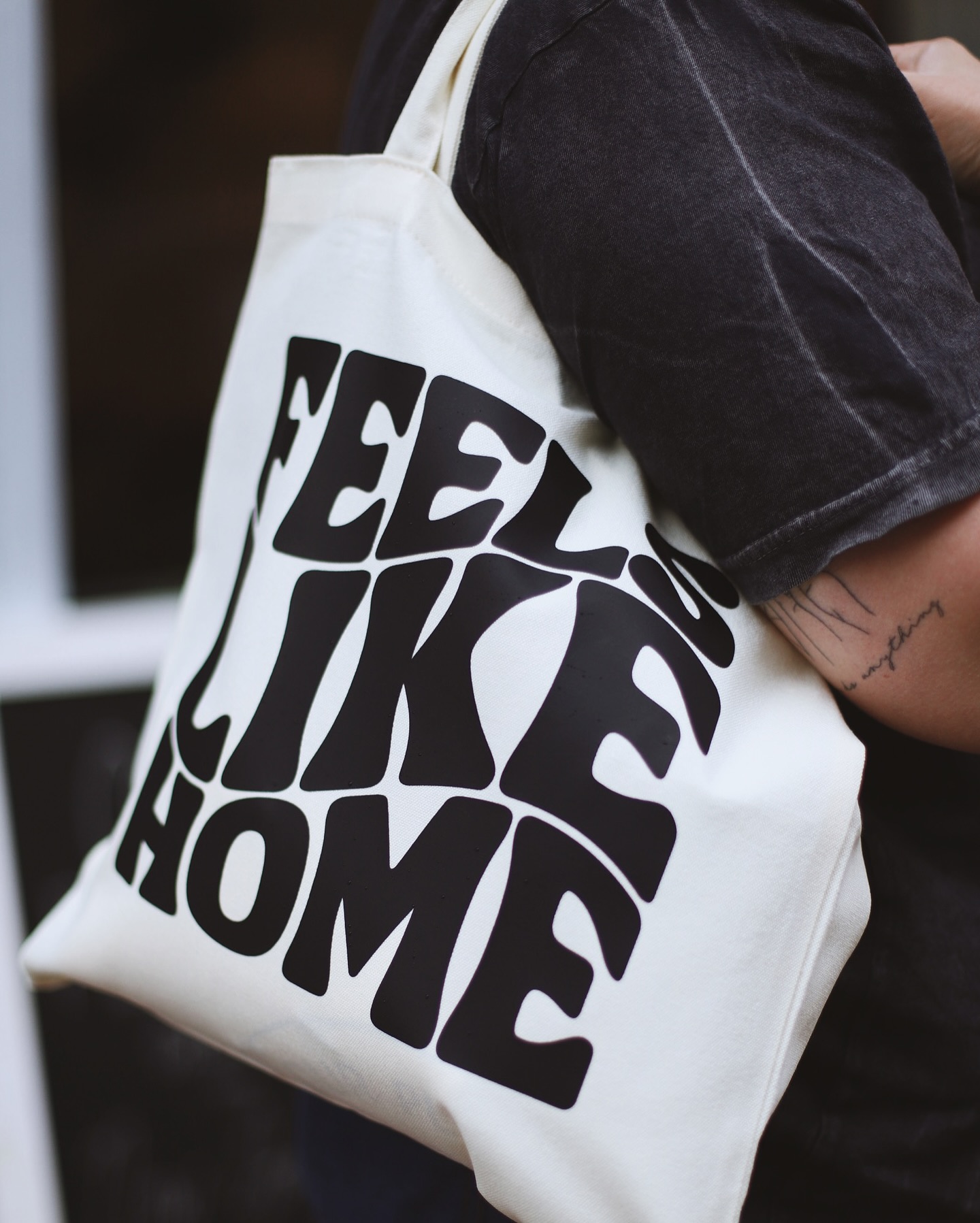 White tote bag printed with the words Feels Like Home